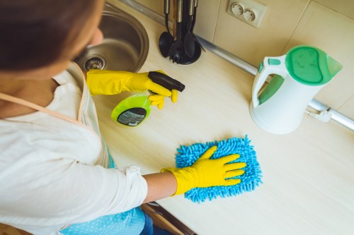 Local cleaner treating stains on a corner sofa in Utton